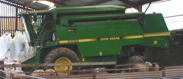 John Deere combine parked in shed